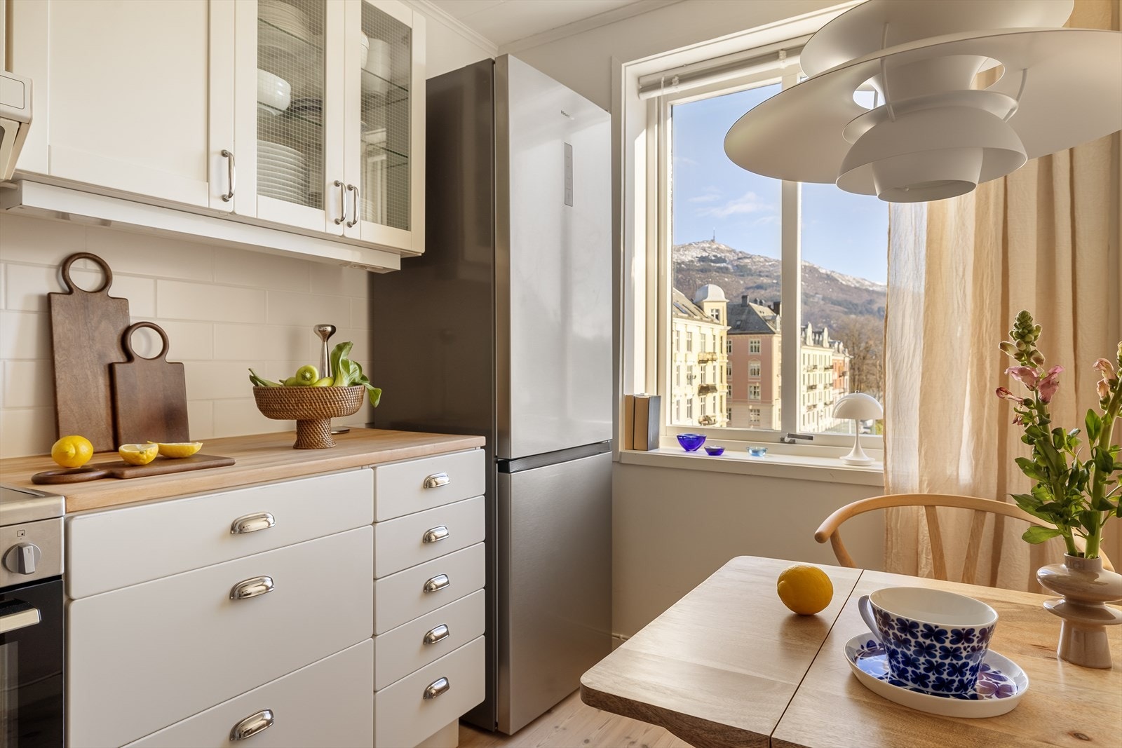 Kjøkkenet kombinerer gode arbeidssoner med en sjarmerende spiseplass ved vinduet, en sjelden og verdifull kvalitet i en byleilighet. Galleribilde