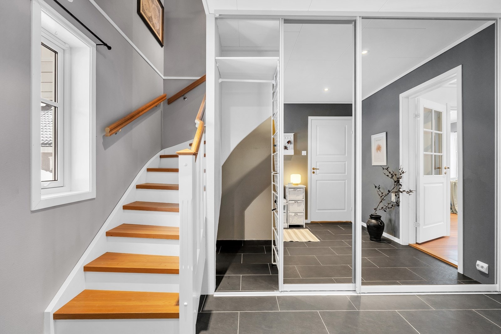 Praktisk skyvedørsgarderobe med ekstra oppbevaringsplass. Trapp som tar det opp til boligens andre plan. Galleribilde