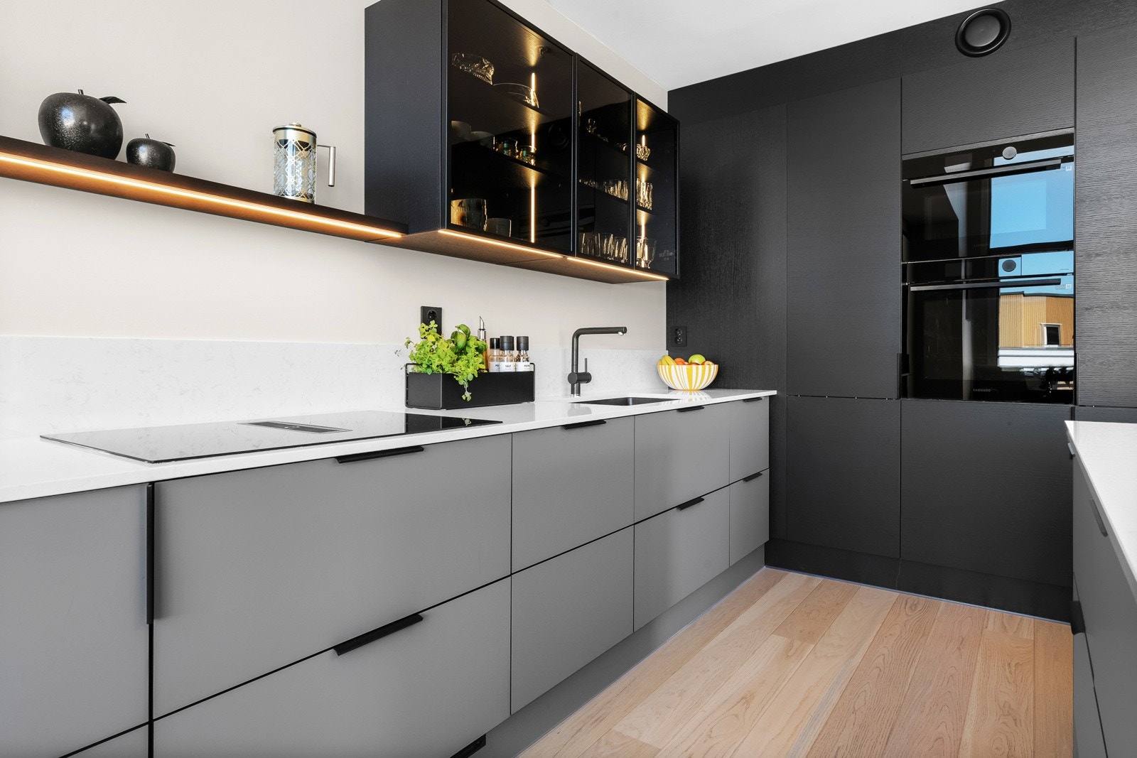 Kjøkkeninnredningen har glatte, grå fronter fra 2023 og benkeplater av kompositt. Galleribilde