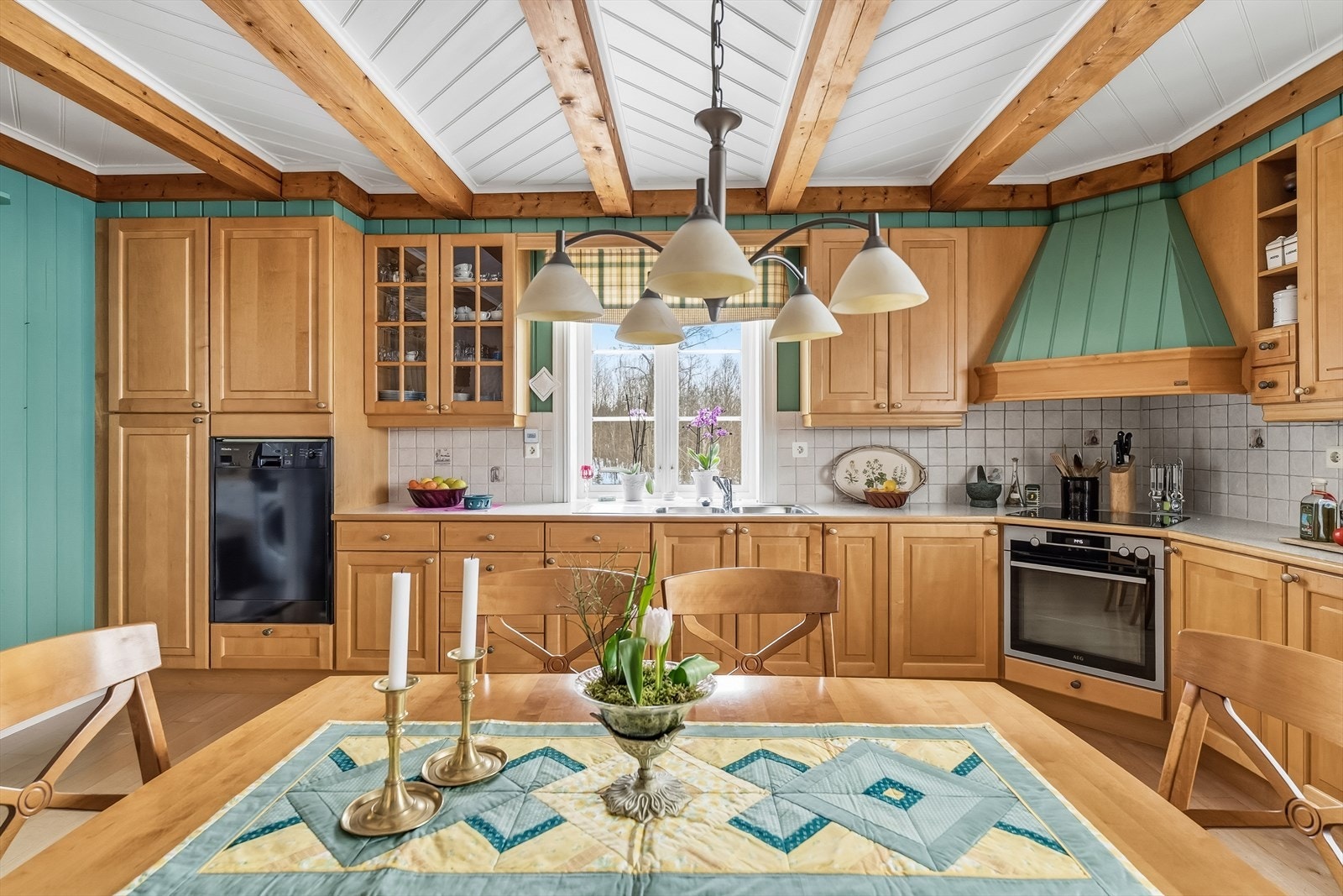 Kjøkkenet har profilerte fronter av heltre, integrerte hvitevarer og platetopp. Galleribilde