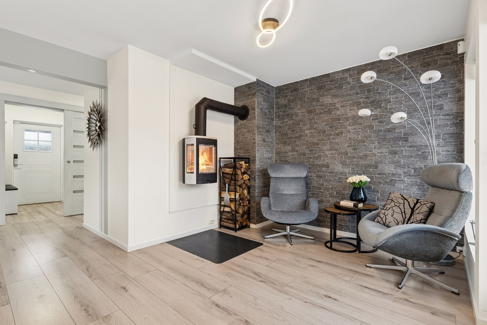 Stuen er delt opp i flere seksjoner, med plass til både sitte,- spise og sofagrupper. Her i sittegruppen er det satt inn pen peis for hyggelig atmosfære. Galleribilde