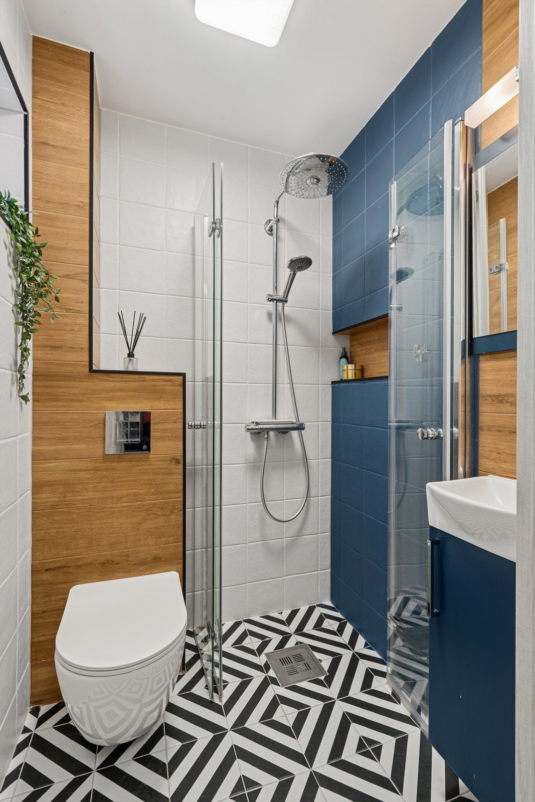 Gjestebad i 1. etasje med flislagte overflater, vegghengt toalett og dusj. Svært godt utnyttet! Galleribilde