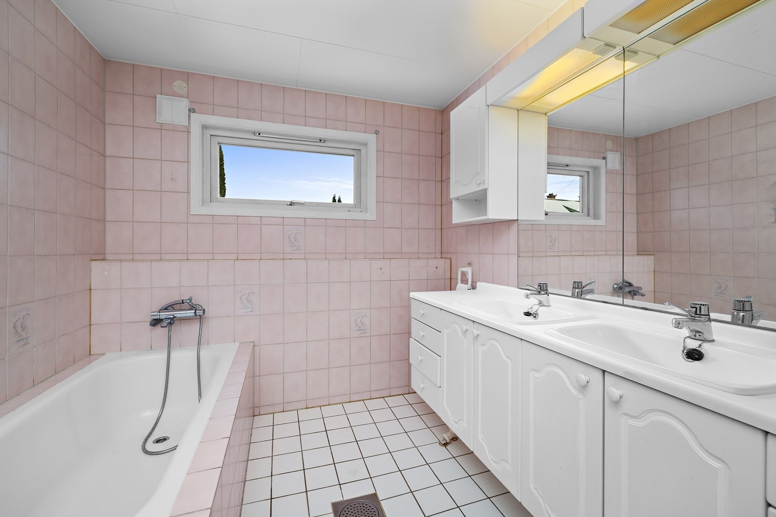 Badet i underetasjen har flislagt gulv, innredning med dobbel servant - Modernisering må påregnes. Galleribilde