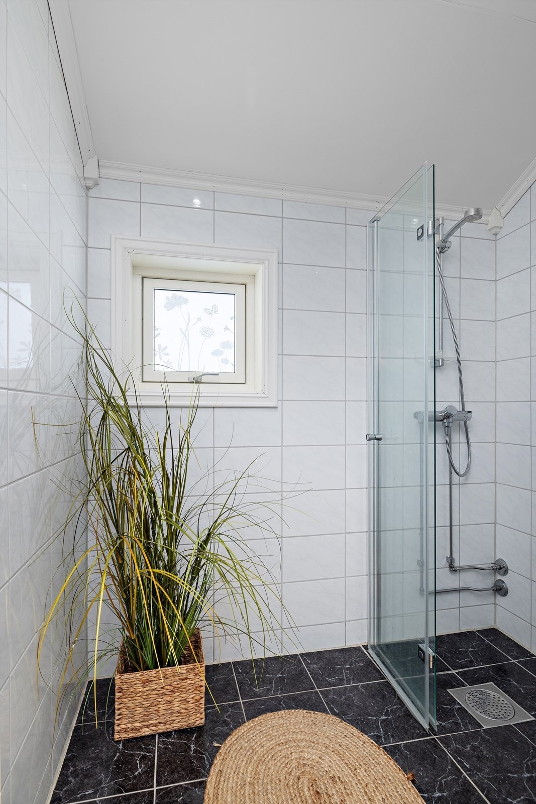 Badet er utstyrt med en dusjnisje med glassdører og mekanisk avtrekk. Galleribilde