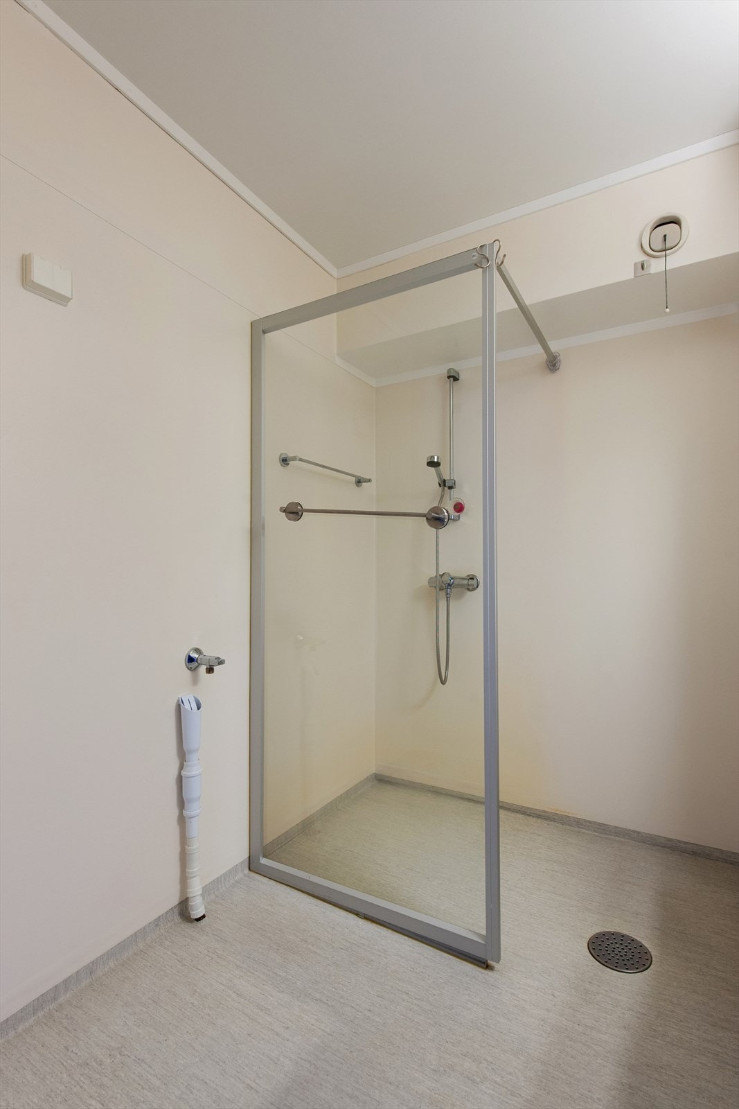 Rommet har baderomsinnredning med servant og ett- greps blandebatteri. Opplegg for vaskemaskin. Veggmontert dusj, dusjvegg av glass. Galleribilde