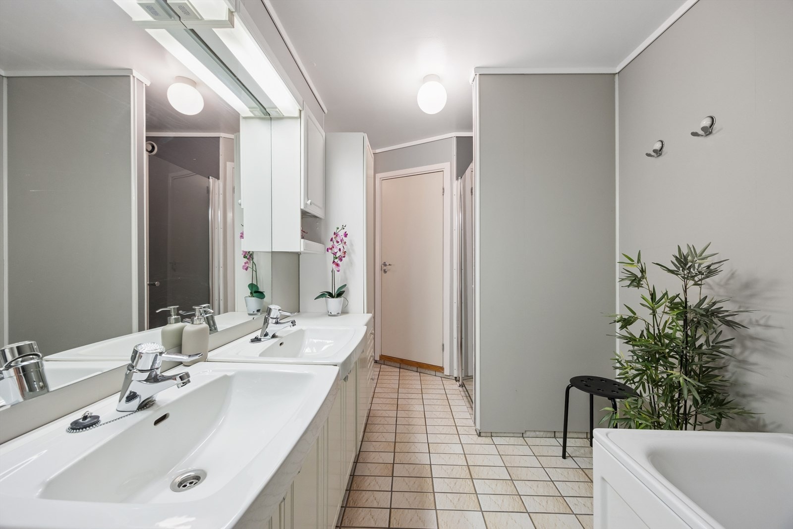 Svært romslig baderomsinnredning med dobbel servant og mye oppbevaringsplass for baderomsartikler. Galleribilde