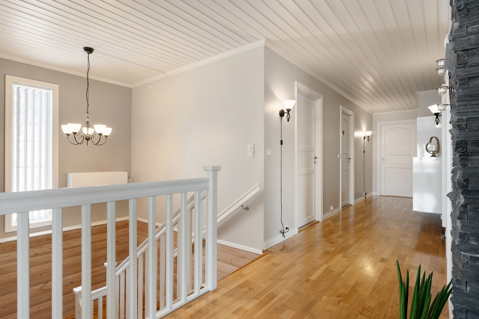 Trappegang med vindu som slipper inn naturlig dagslys. Lysekronen medfølger salget. Galleribilde