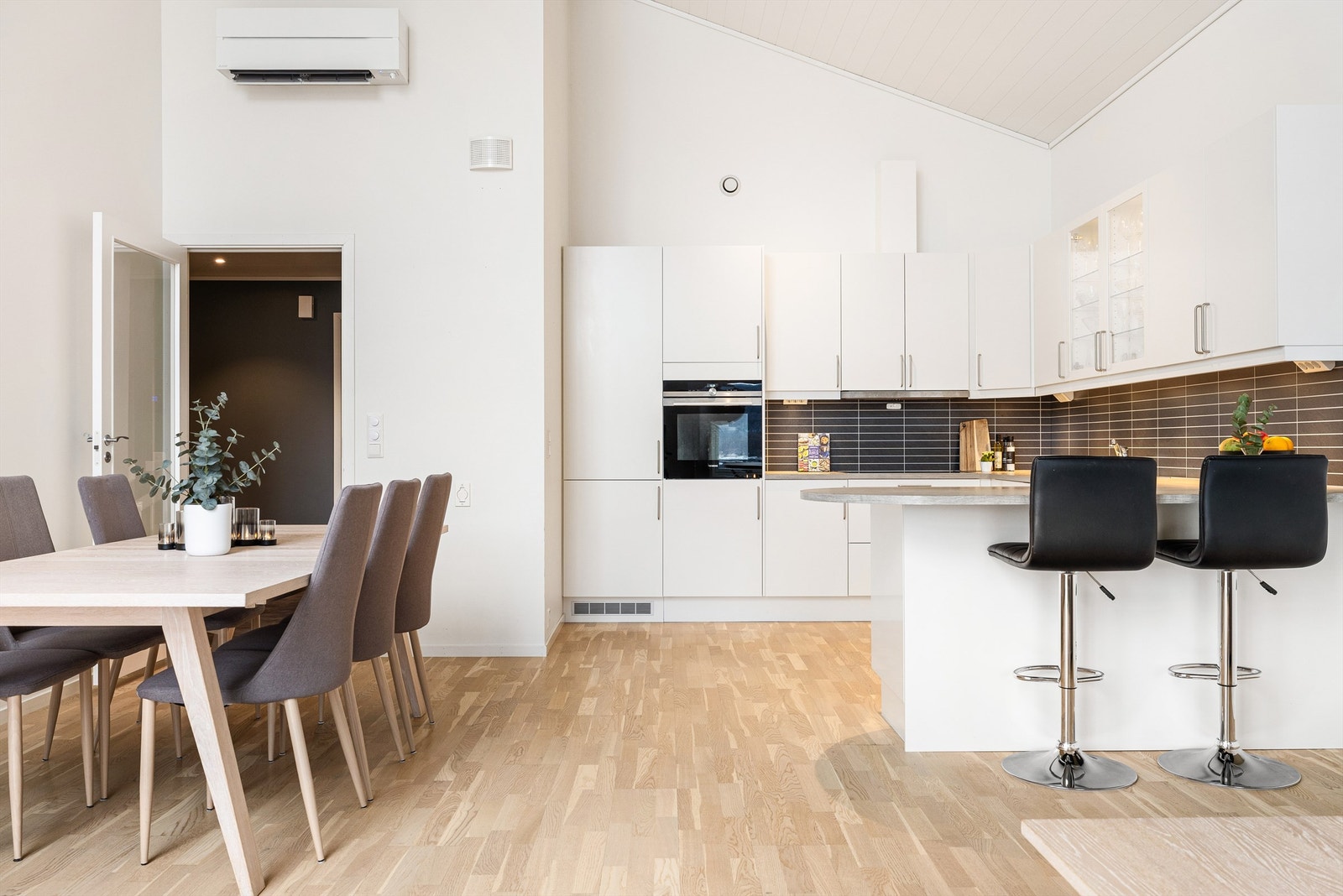 Her er det god plass til spisestue og en praktisk halvøy med barstoler Galleribilde