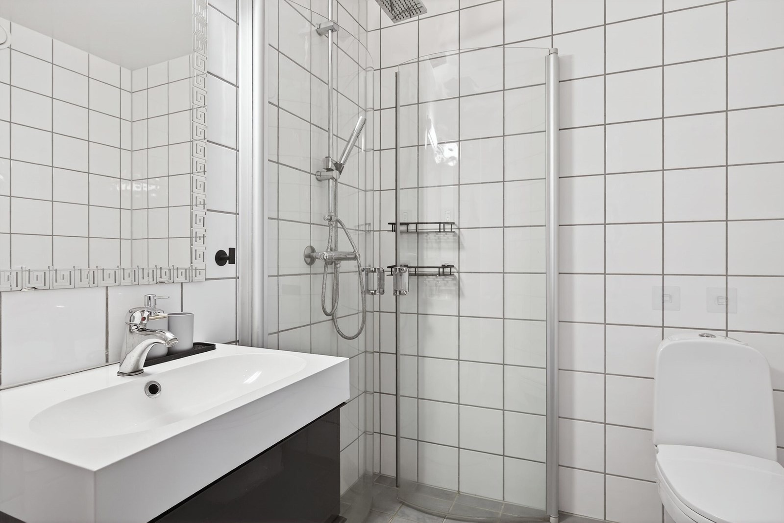 Badet er utstyrt med innglasset dusjhjørne, som gir en funksjonell og lettstelt løsning. Galleribilde