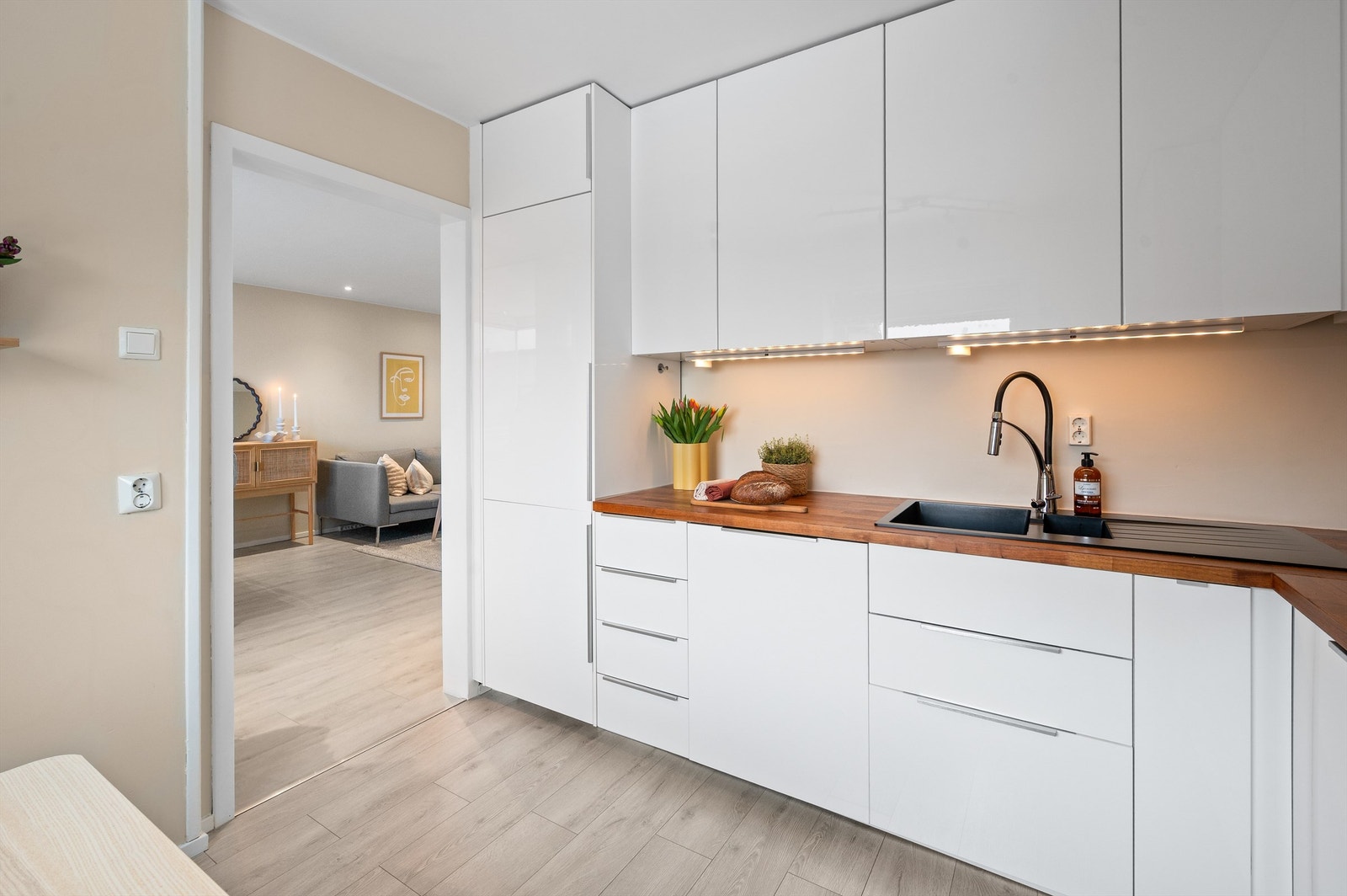 Kjøkkenet har benkeplate i finer med nedfelt vask og kullfilterventilator over kokeplassen. Galleribilde