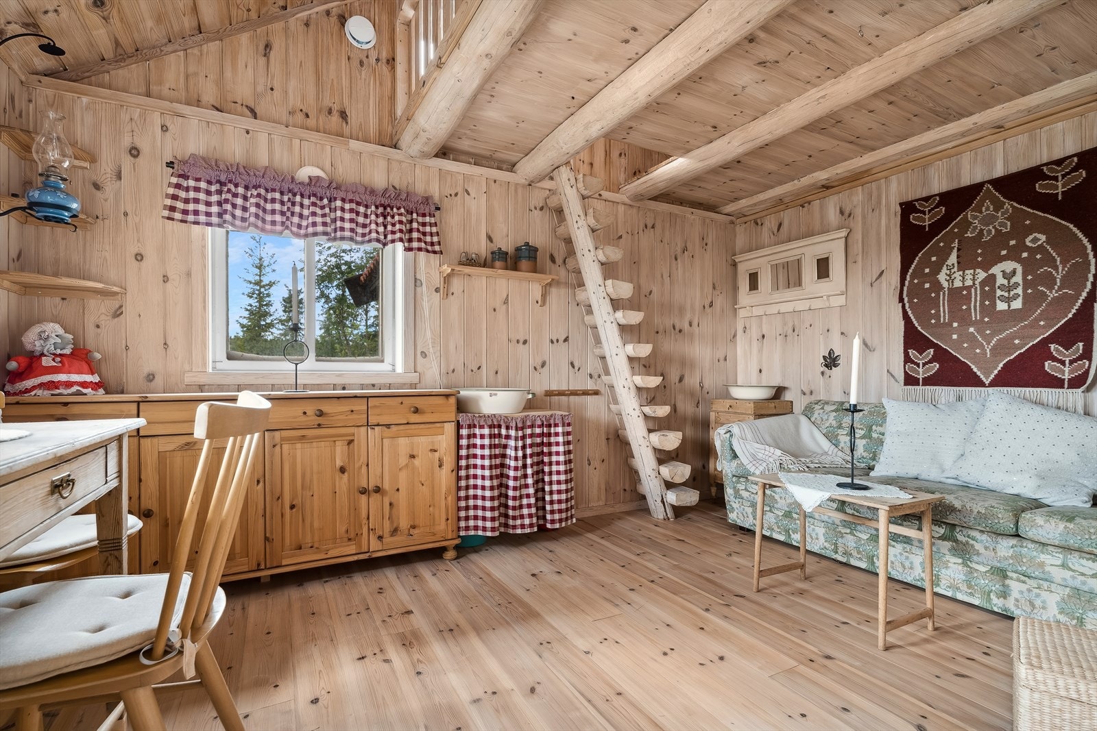 Stuen i annekset har behandlet panel på veggene og heltre gulv. Rommet er romslig med gode møbleringsmuligheter. Det er tretrapp opp til hemsen i et hjørne. Galleribilde