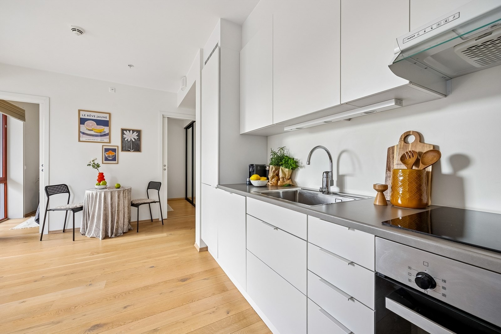 Den åpne løsningen mellom stue og kjøkken skaper et sosialt og luftig allrom på 18 m². Galleribilde