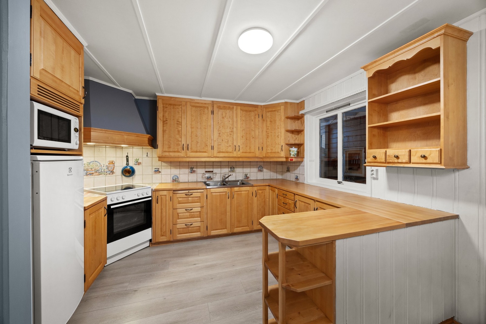 Praktisk kjøkkeninnredning med avsatt plass for hvitevarer. Godt med benk- og oppbevaringsplass. Galleribilde