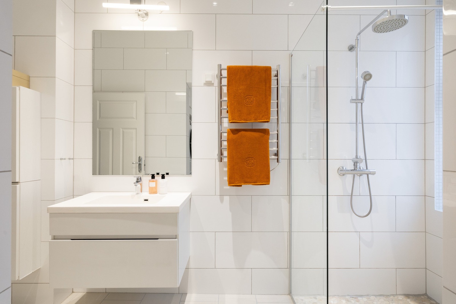 Badet består av servantskap med med nedfelt servant, dusjsone med innfelte dusjdører i herdet glass og separat WC-rom med vegghengt toalett. Galleribilde