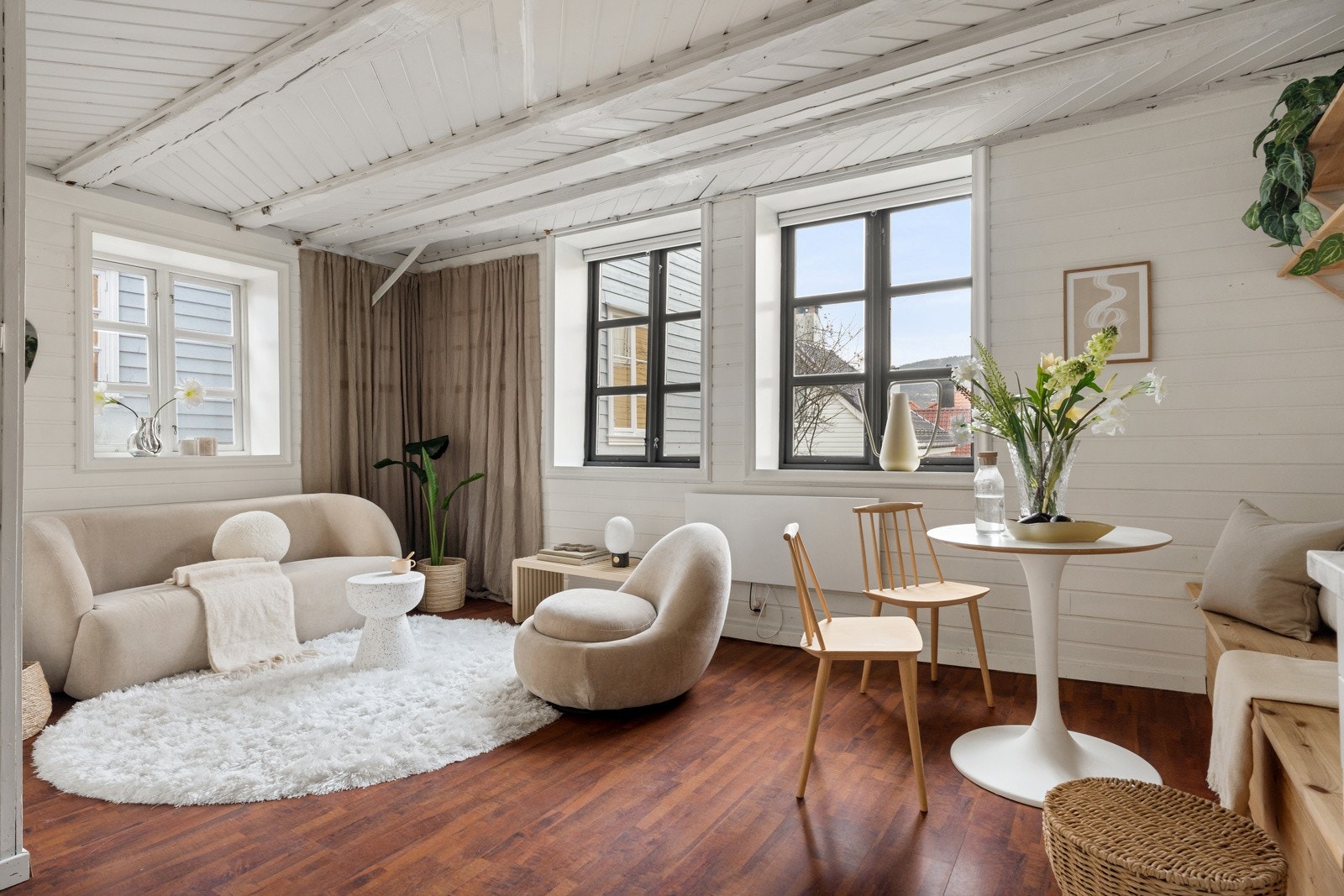 Stue og kjøkken er samlet i en åpen løsning med godt lysinnslipp, noe som gir rommet en luftig og hyggelig atmosfære Galleribilde