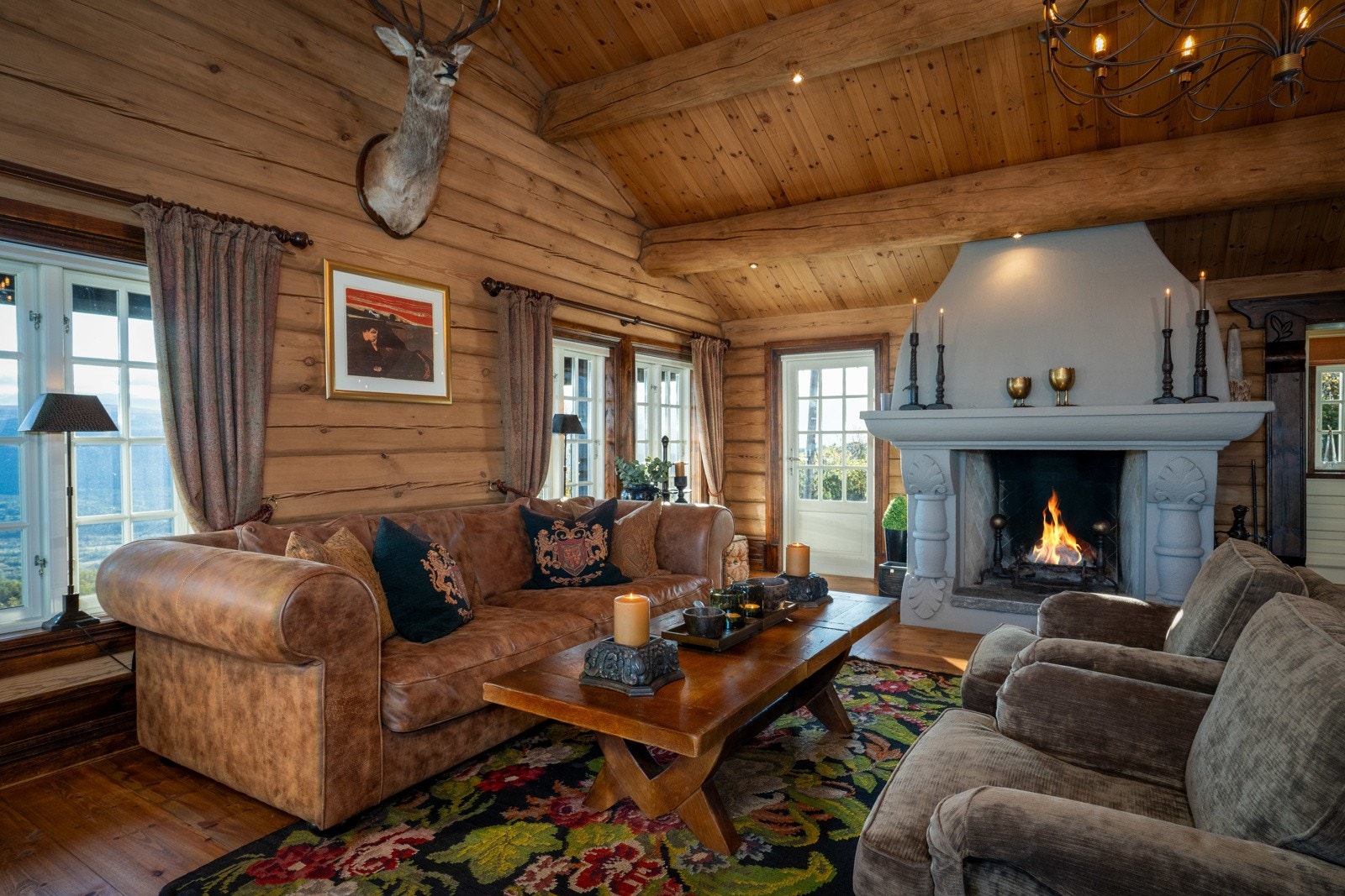 Stuen er et eventyrlig rom som oppleves både lunt og romslig. Her er det takhøyde til mønet, flotte tømmervegger, vannbåren guvvarme og ekstra brede tregulv. I midten pryder en meget flott peis som både gir hygge og varme. Galleribilde