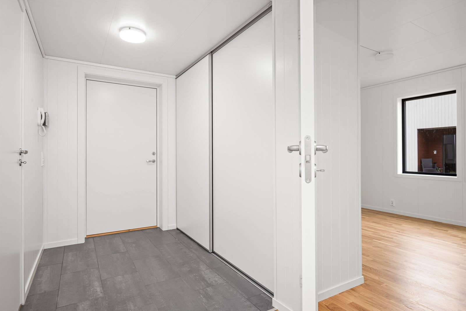 Entreen er flislagt med varmekabler og har integrert skyvedørsgarderobe. Galleribilde