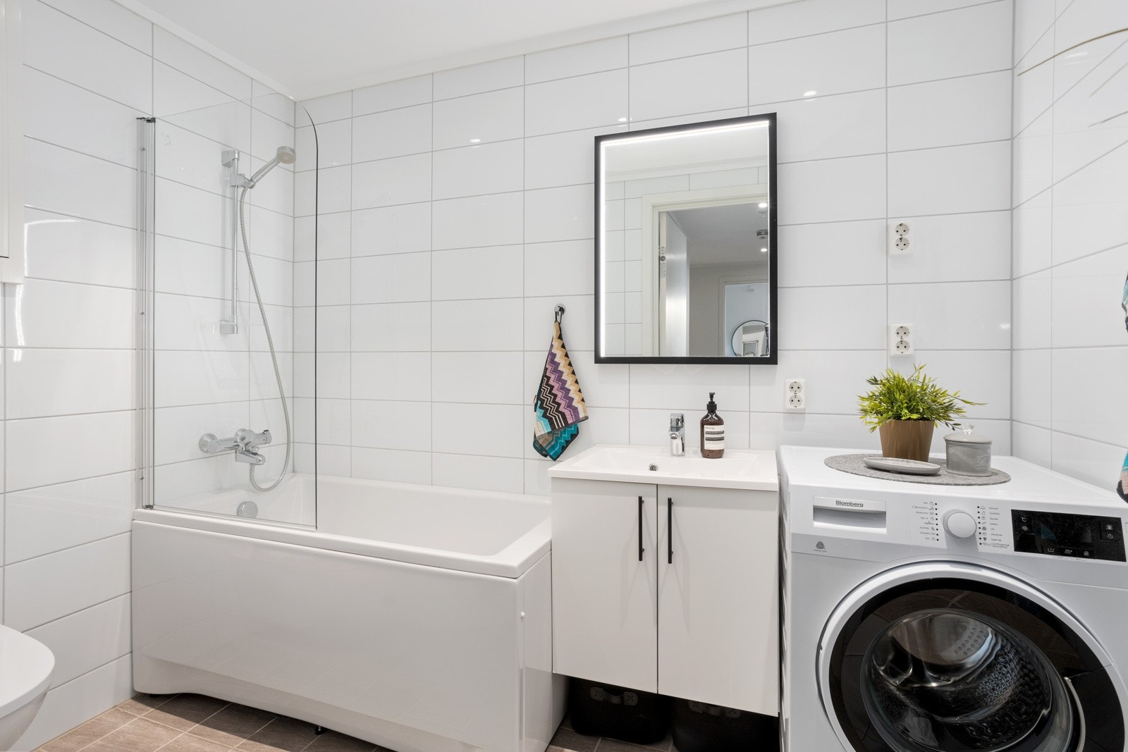 Praktisk bad med kompakt badekar som også har dusjmulighet. Galleribilde