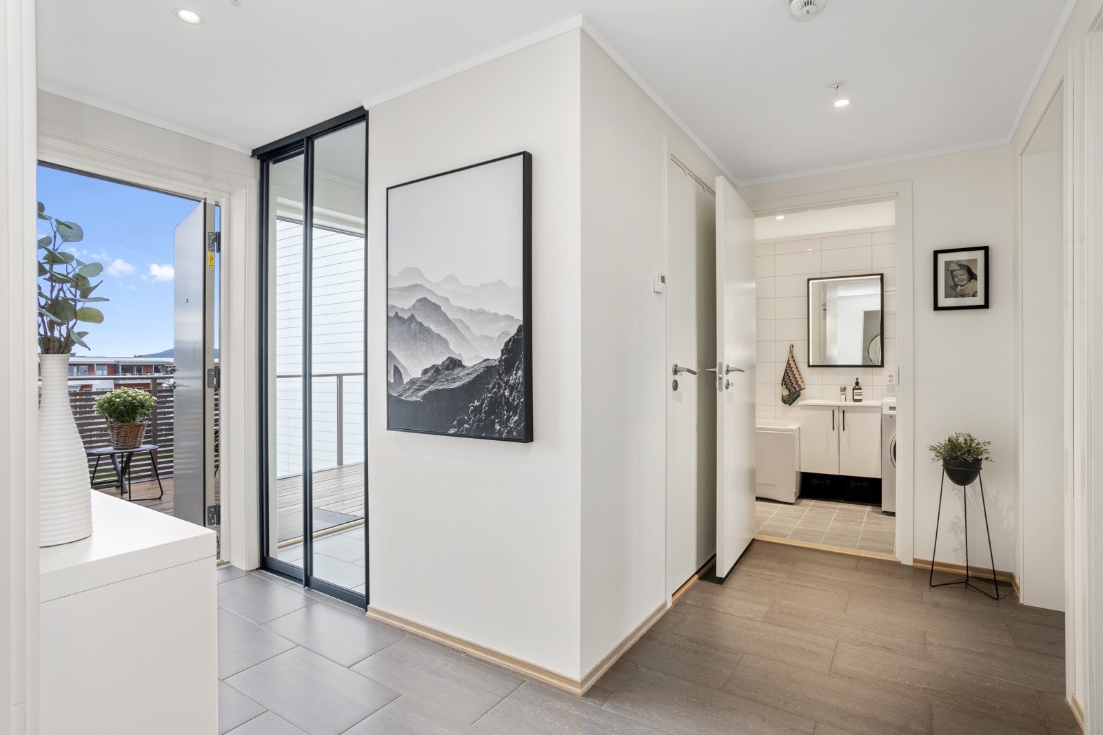 Entréen er flislagt og har downlightsbelysning. Praktisk garderobe med skyvedører ved inngangspartiet. Galleribilde