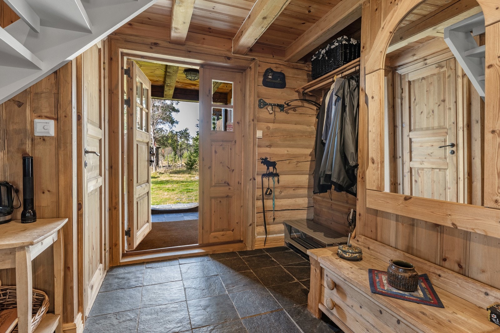 Veggene består av tømmer og trepanel, og gulvet har fliser som gir en robust overflate for daglig bruk. Galleribilde