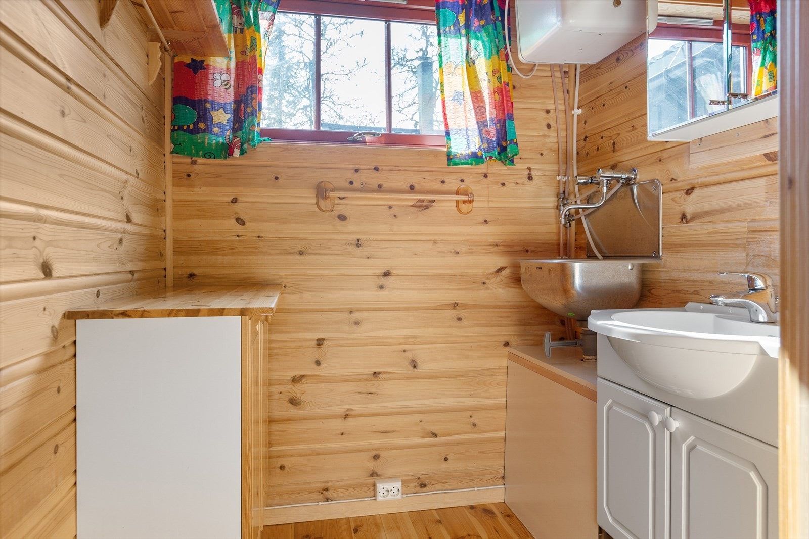 Vaskerom for hygienisk bruk med servantskap i folierte plater, speilskap og utslagsvask med kran. Galleribilde