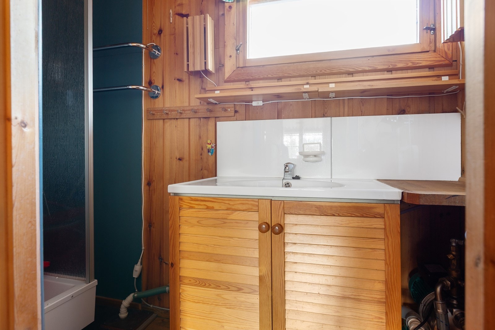 Badet er konstruert som et enkelt baderom og er ikke å betrakte som et fullverdig våtrom. Her finner du servantskap i plater og dusjkabinett med tråpumpe. Galleribilde