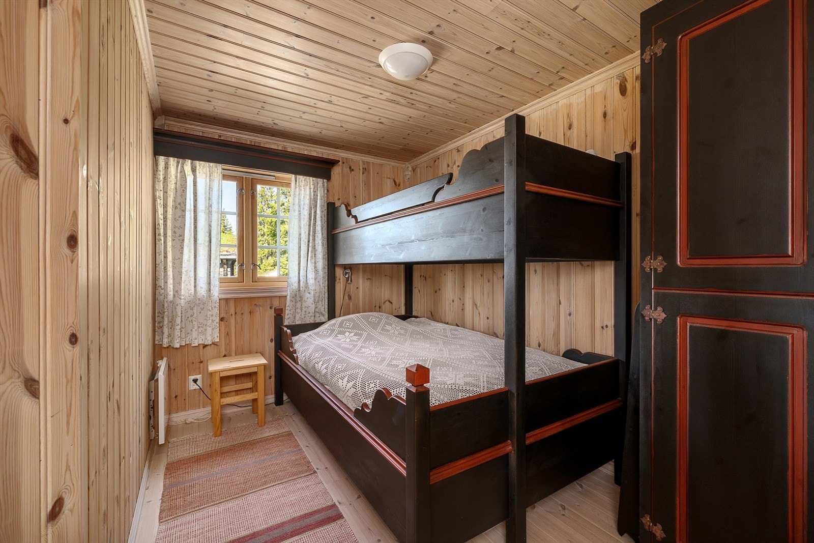 Soverom 2 er innredet med familiekøye og skap for oppbevaring i samme stil som hytta. Galleribilde