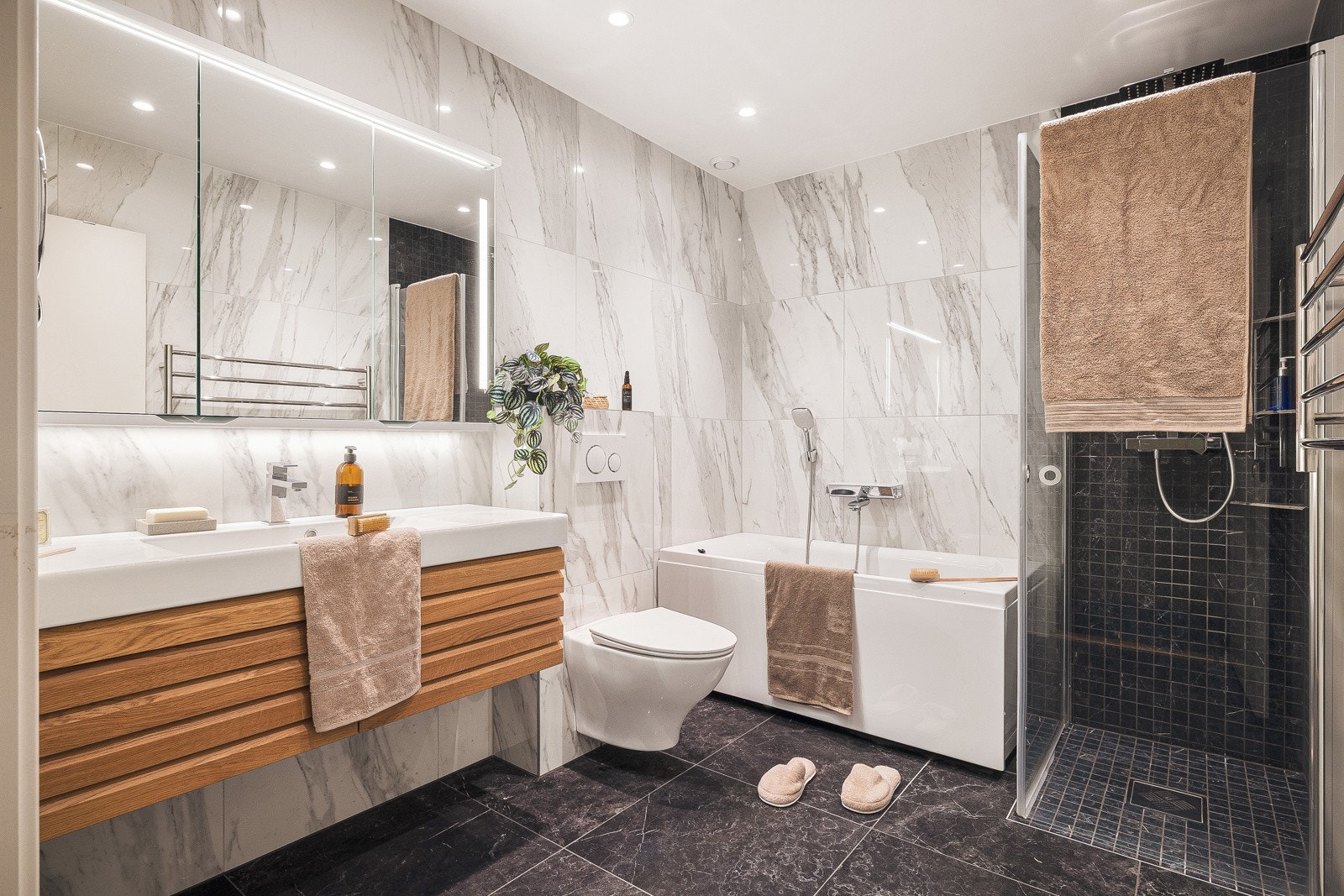 Bad i underetasje er innredet med baderomsinnredning med nedfelt servant, vegghengt toalett, dusjhjørne samt badekar. Galleribilde