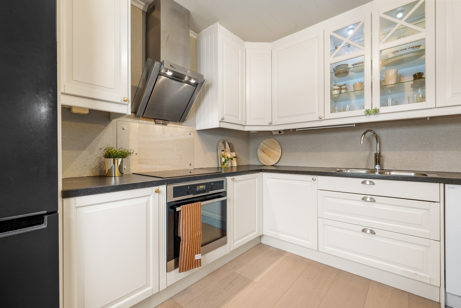 Delikat kjøkken med integrert stekeovn og platetopp med moderne avtrekksvifte over, samt innebygd oppvaskmaskin. Galleribilde