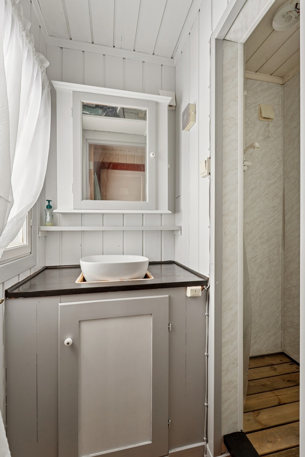 Vaskerommet er innredet med servant og har et dusjkar med avløp for gråvann. Galleribilde