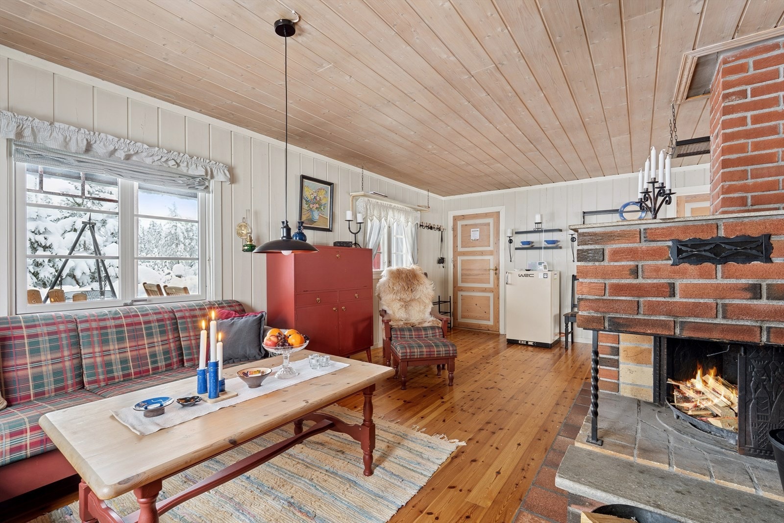 Den sentralt plasserte mursteinspipen med peisinnsats og vedovn gir god varme og hygge. Galleribilde