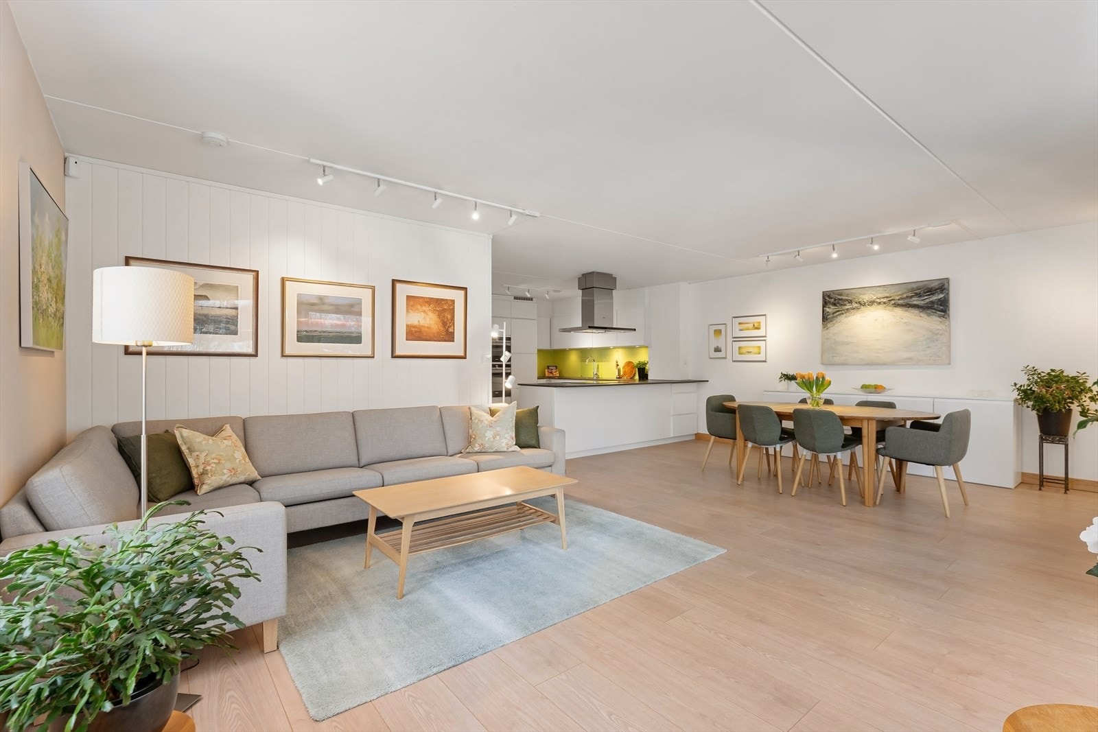 Lys og åpen stue med god flyt mellom sonene, som naturlig binder sammen spiseplass og kjøkken. Galleribilde