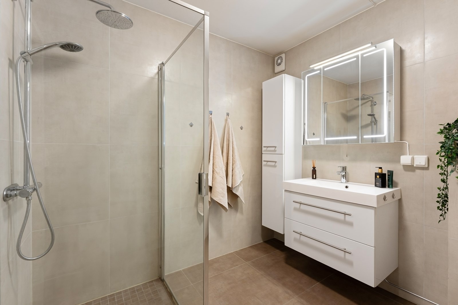 Rommet er utstyrt med innredning med nedfelt servant, speilskap med lyslist, veggmontert toalett og dusjhjørne med dusjvegger. Galleribilde