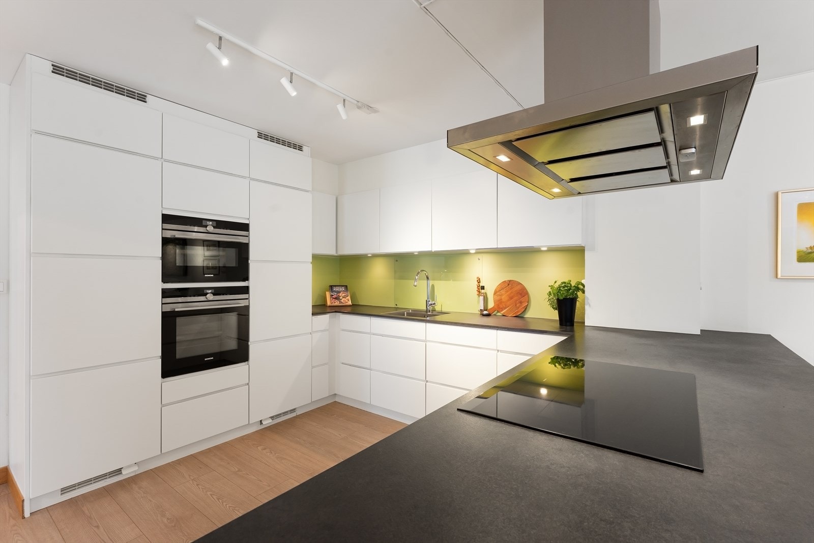 innredning med hvite glatte fronter og integrerte håndtak. Galleribilde