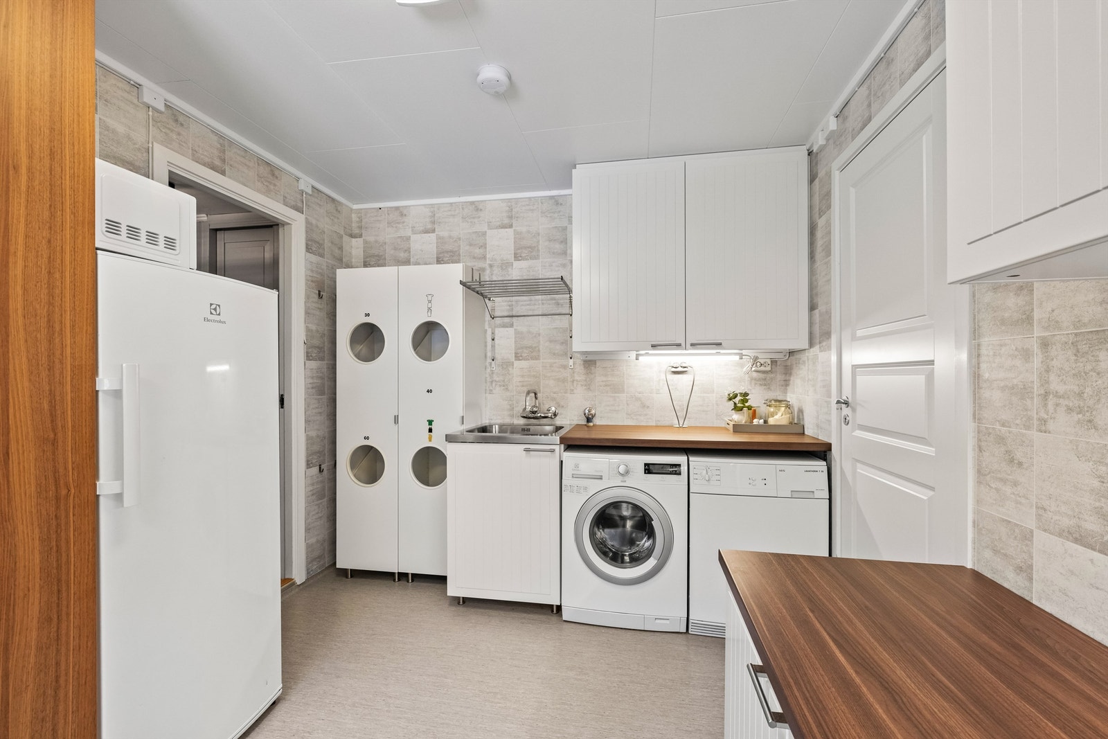 Rommet har opplegg for vaskemaskin og tørketrommel, samt god benke- og skapplass. Galleribilde