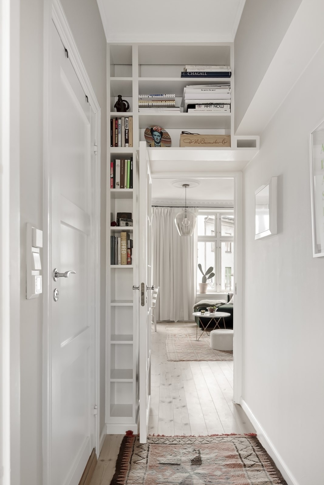Mellomgangen til baderom og soverom har fine detaljer med plassbygde hyller rundt døren til stuen. Galleribilde