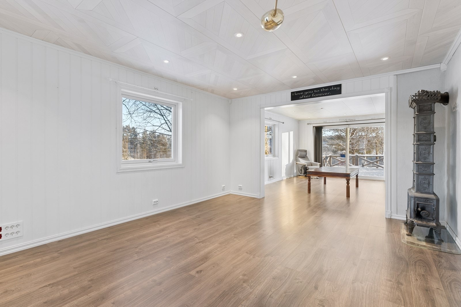 En restaurert, eldre etasjeovn er et sentralt element i stuen og gir god tilleggsvarme. Galleribilde