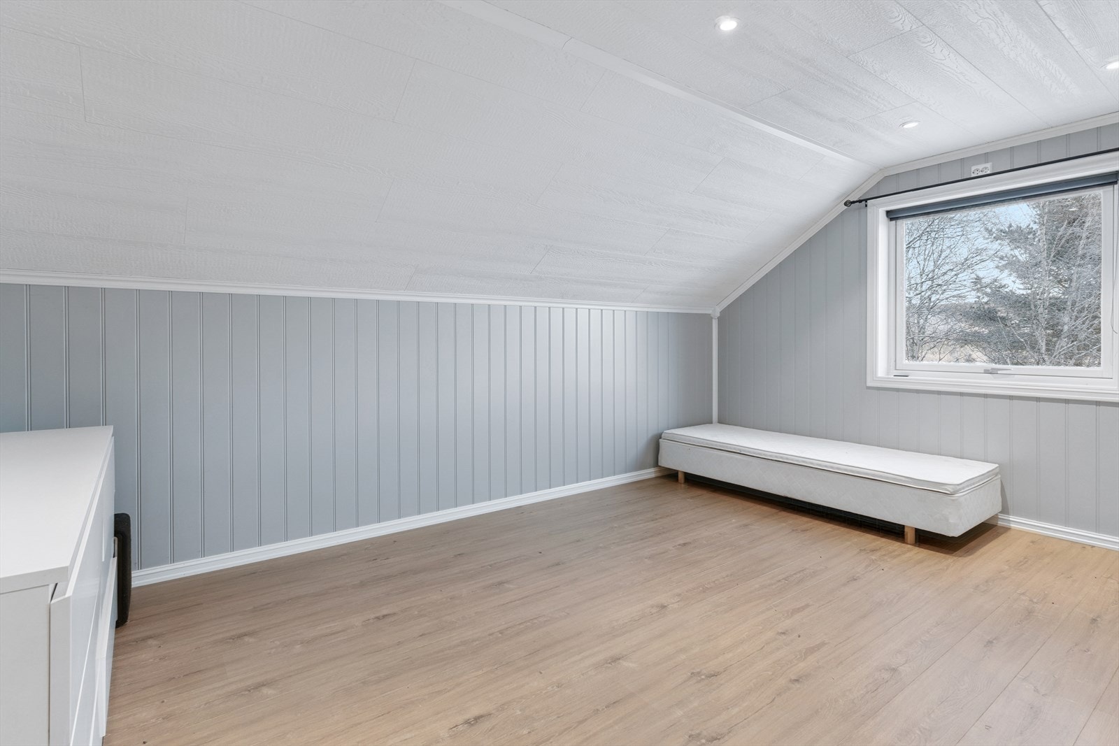 Begge rommene har laminatgulv og malte panelplater på veggene. Galleribilde