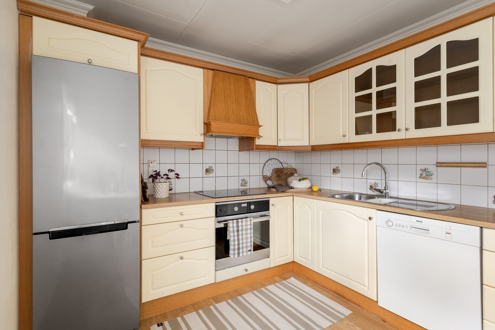 Kjøkkenet har integrert komfyr og platetopp. Fliser over benkeplate. Galleribilde