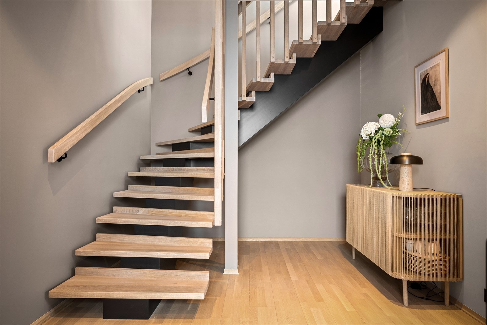 Elegant trapp i heltre uten sidevanger - som binder etasjene sammen og gir et stilfullt preg. Gode lagringsmuligheter under trappen. Galleribilde