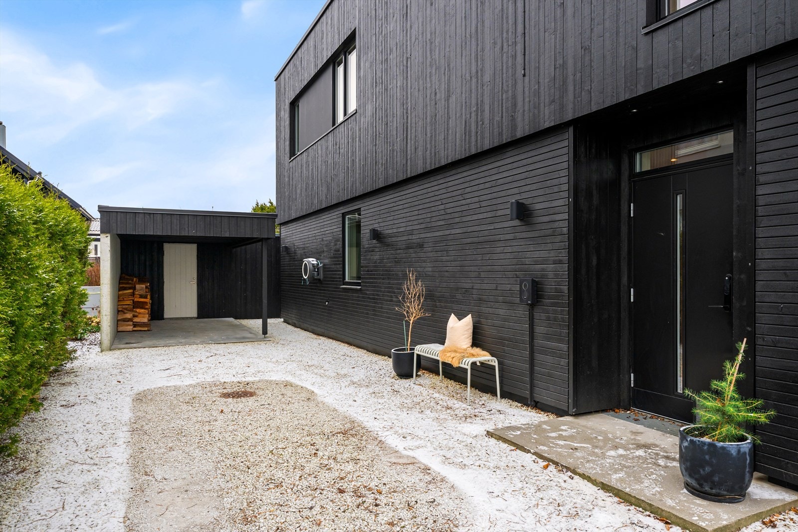 Carport og integrert elbil-lader, i tillegg til god plass til parkering av flere biler i gårdsrommet. Galleribilde