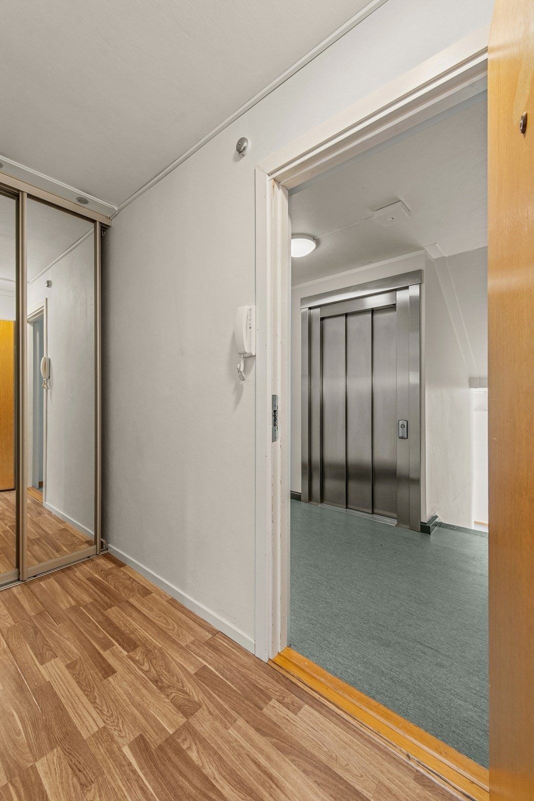 Leiligheten byr på komfortabel adkomst via heis direkte til etasjeplanet, og i entreen møter du en praktisk skyvedørsgarderobe som gir god plass til oppbevaring. Galleribilde