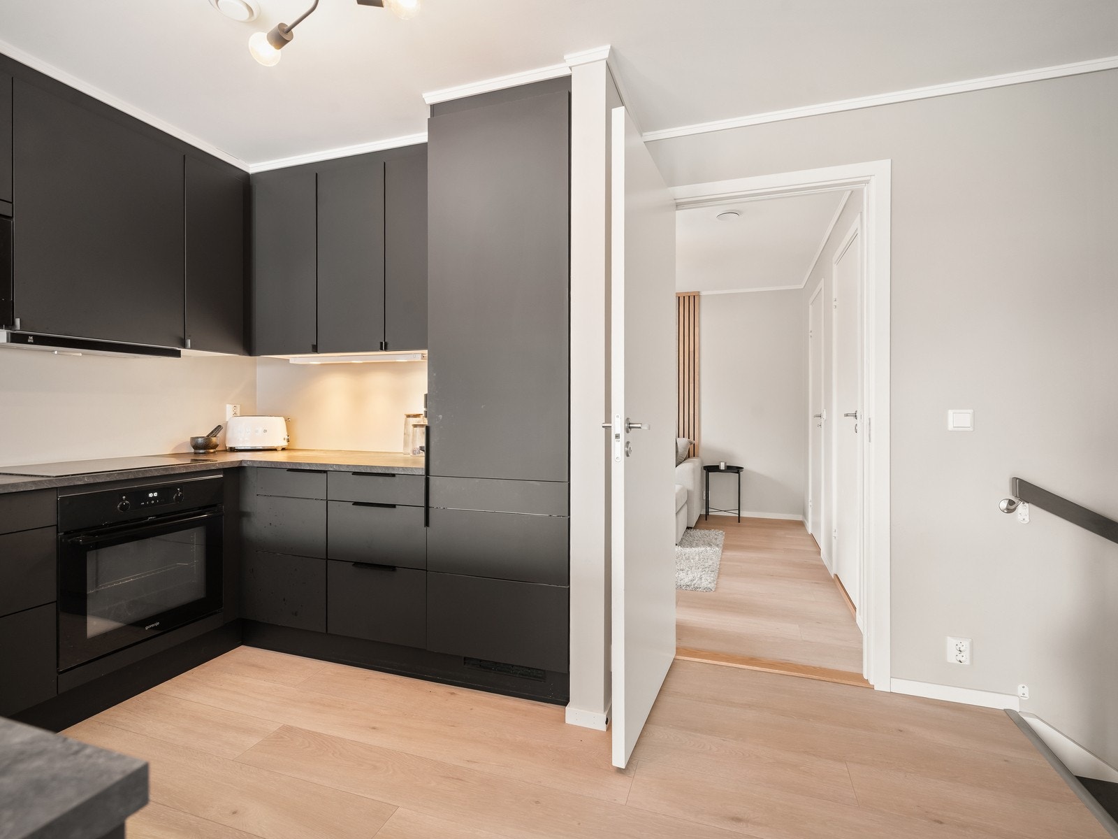 Kjøkkenet har en innredning med glatte fronter og benkeplate i laminat med oppvaskkum. Galleribilde