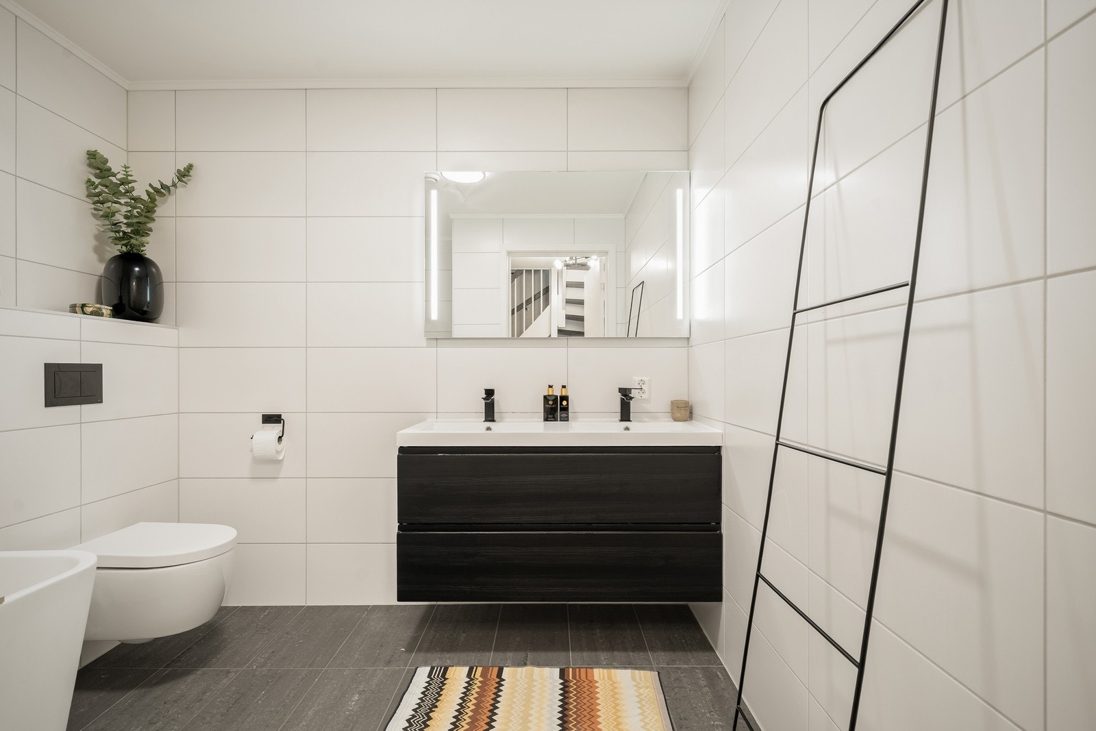 Dette badet i første etasje har flislagte overflater på både vegger og gulv, med elektriske varmekabler i gulvet, samt malt tak. Galleribilde