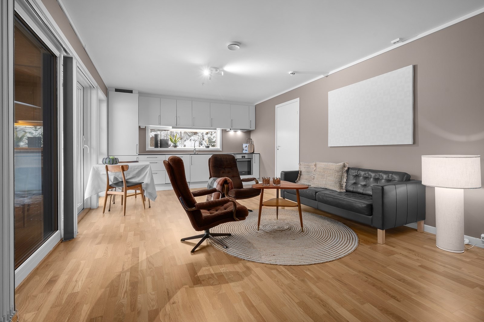 Åpen stue/kjøkken løsning med plass til sittegrupper og spisebord Galleribilde