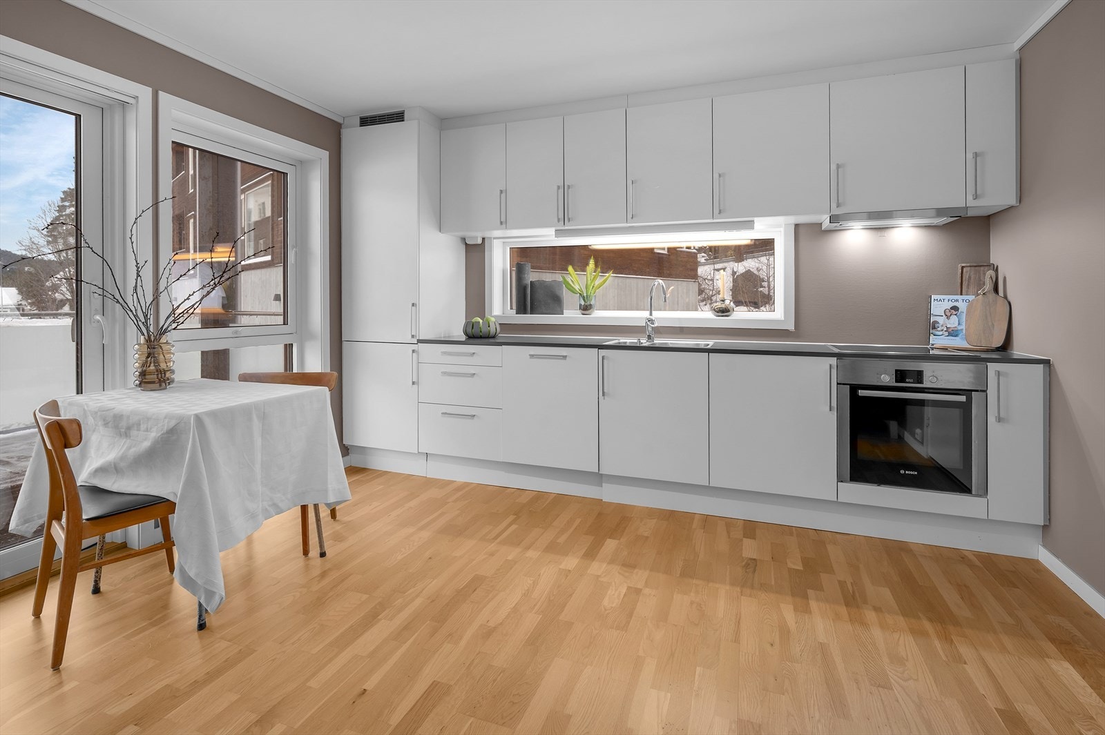 Flott kjøkken med hvite fronter og god skap- og benkeplass Galleribilde