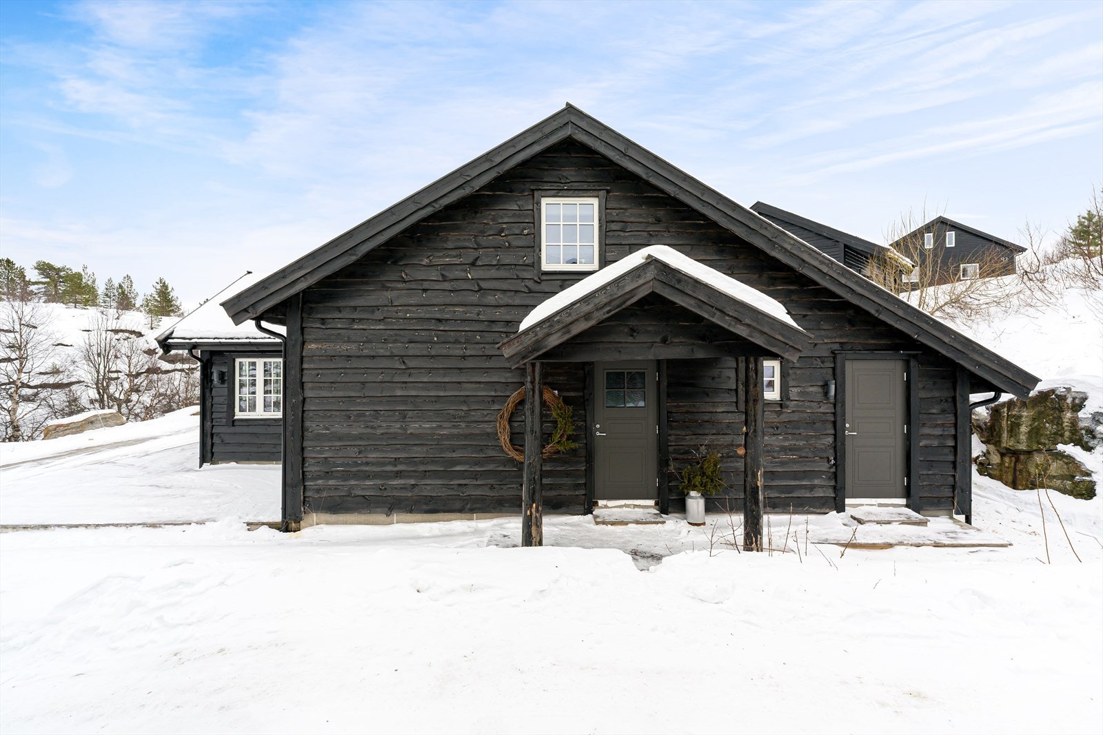 Overbygget inngangsparti og dør inn til bod Galleribilde