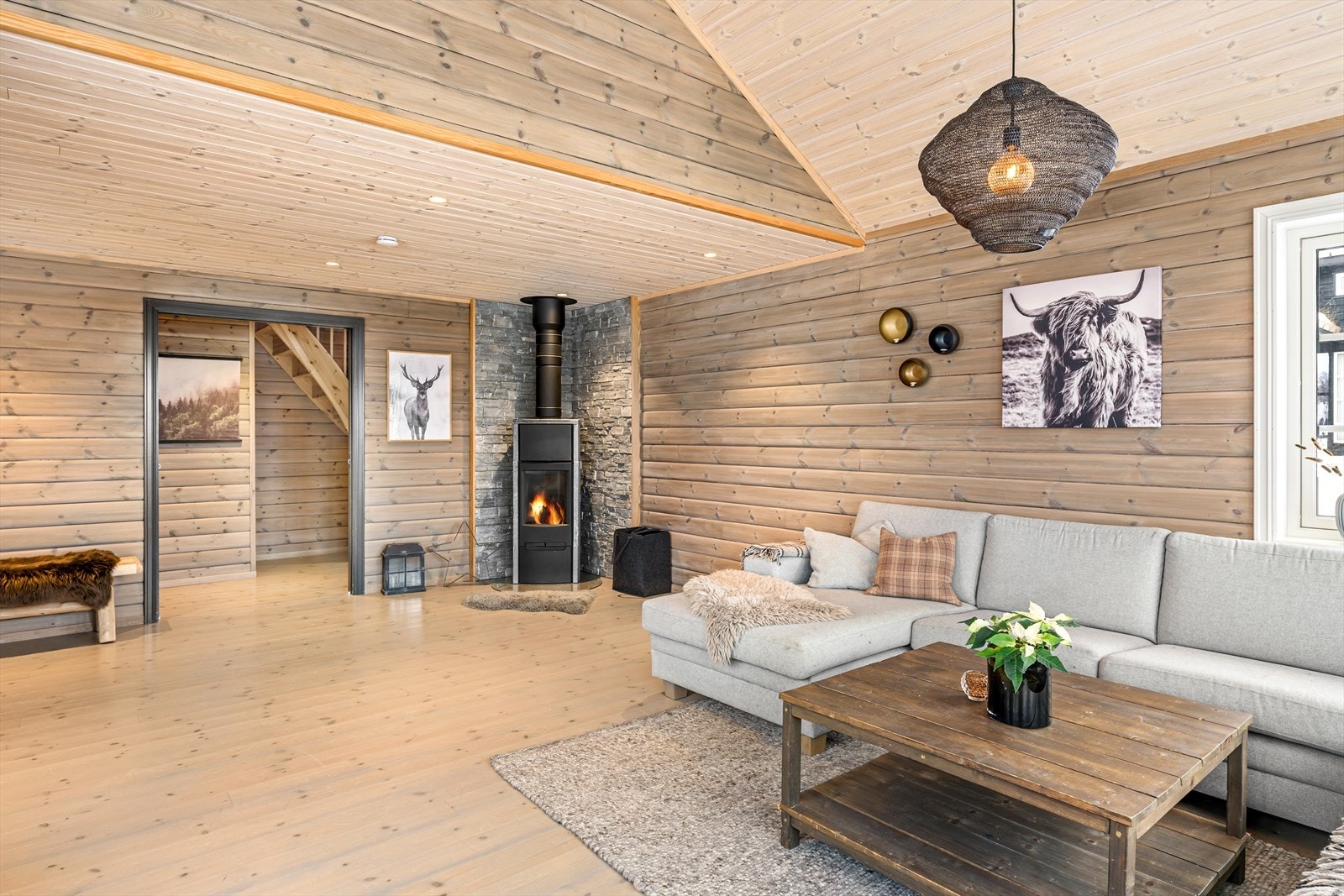 Stor stue med panel på vegger og behandlet furugulv. Galleribilde