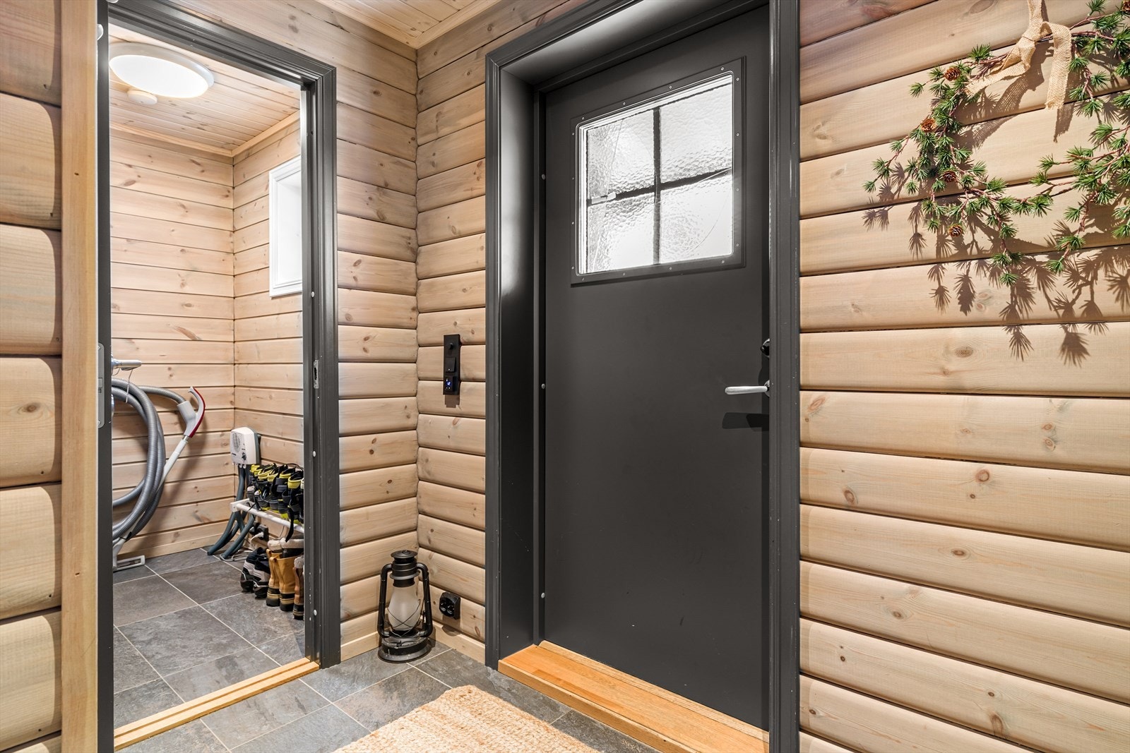 Entre/gang med fliser på gulv med varmekabler under. Adkomst til praktisk bod. Galleribilde