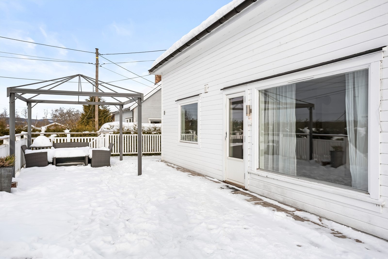 Boligen har hvitmalt, liggende kledning og vinduer med to-lags glass. Galleribilde